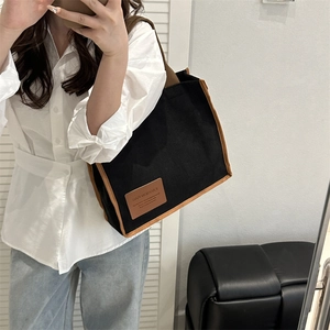 Minimalist canvas tote bag with brown leather trim shown in a stylish mirror selfie