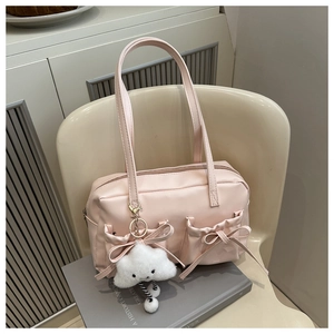Détail d'un sac oreiller rose en cuir avec charm nuage et poches à nœuds décoratives
