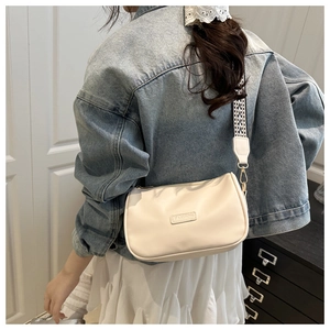 Detail of off-white crossbody bag featuring fashion label and wide geometric strap
