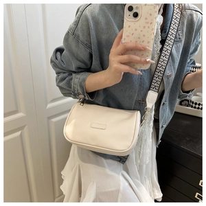 Chic ivory pillow bag with a geometric woven strap shown on a model for daily styling