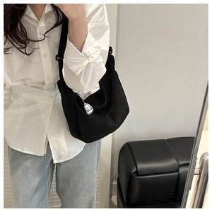Détail du sac hobo en velours côtelé noir avec bandoulière et pendentif nuage