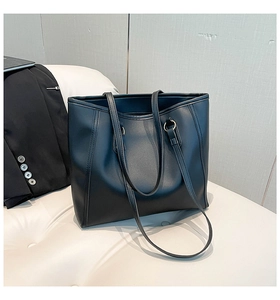 Macro detail of black matte faux leather tote bag with elegant vertical stitching