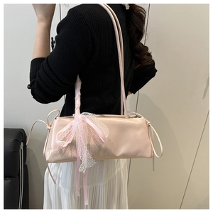 Pale pink baguette bag side view with white lace bow and thin double shoulder straps
