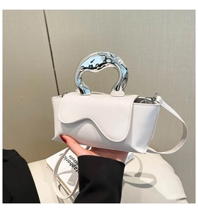 Close-up of a white wave flap bag featuring a silver fluid metal handle and smooth leather