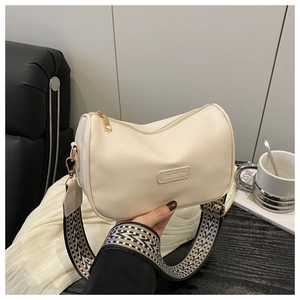Detail of cream pillow bag with chic black and white geometric jacquard wide strap