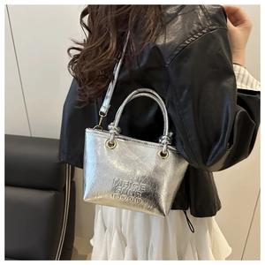 Detail of silver metallic bucket bag with logo print and adjustable shoulder strap