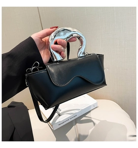 Detail of black leather crossbody bag with liquid metal handle and wavy flap design