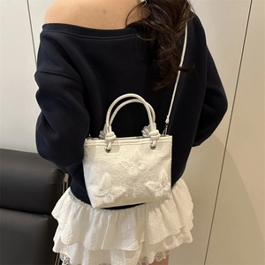 White bucket bag with 3D butterfly embroidery and dual handles for a stylish look