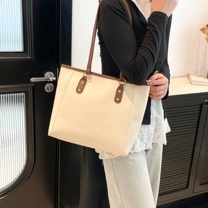 Chic off-white commuter tote bag with brown leather shoulder straps and metal rivets