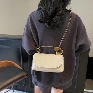 Cream leather handbag with unique large gold pin handle and chain strap for women