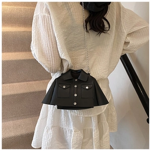Detail of unique black jacket-shaped crossbody bag with metal buttons and chain strap
