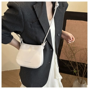 Detail of minimalist off-white bucket bag with rope knot strap and FASHION & BAGS logo