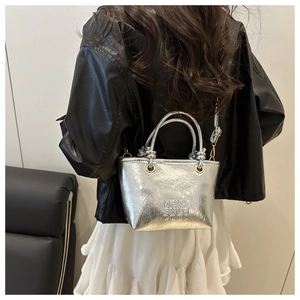 Detail of silver metallic tote bag with crinkled texture and embossed MEIGE text