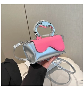 Detail of silver metallic mini bag with pink wavy flap and chunky chrome handle