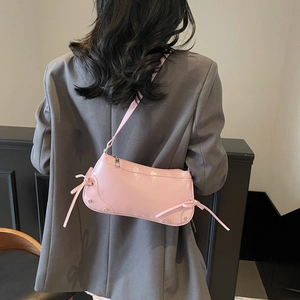Pink glossy patent leather baguette shoulder bag with bow detail and silver studs