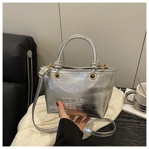Detailed macro view of silver metallic bucket bag with vintage crackle texture and embossing