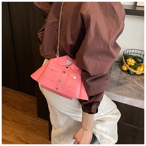 Detail of pink jacket-shaped crossbody bag with metal buttons and fine chain strap