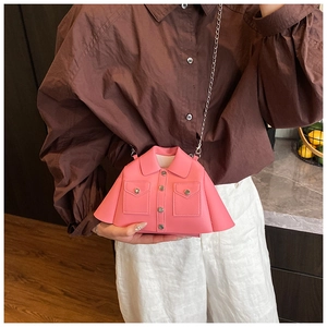 Detailed view of pink jacket-shaped crossbody bag with silver chain strap on model