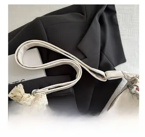Détail du sac en cuir PU blanc cassé avec nœud en dentelle et charm d'ours en peluche