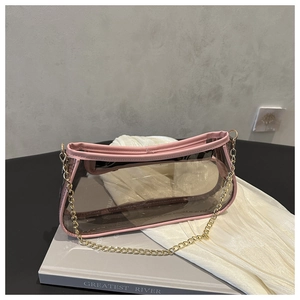 Detail of pink transparent baguette bag with golden chain strap on silk fabric