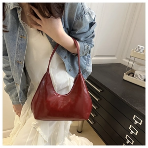 Detail of burgundy crescent bag in glossy patent leather with fashion embossing