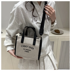 Detail of canvas tote bag with black leather trim and wide adjustable strap