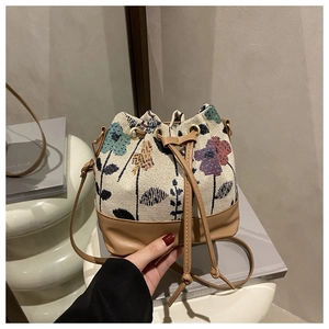 Detail of vintage floral bucket bag with jacquard fabric texture and drawstring closure