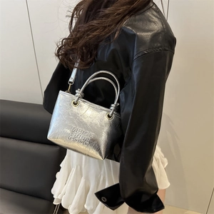 Silver metallic bucket bag with pleated texture and adjustable shoulder strap for women
