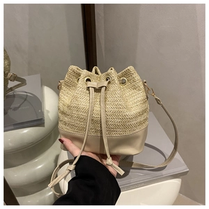 Detailed view of straw bucket bag featuring herringbone texture and beige PU leather base