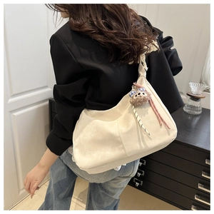 Texture détaillée du cabas en cuir PU blanc cassé avec un adorable porte-clé ours