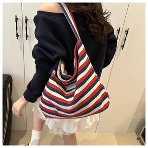 Detail of a large capacity striped canvas tote bag with red, white, and blue woven texture