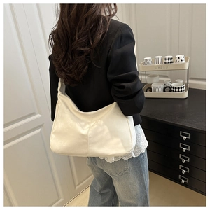 Chic sac hobo en cuir PU blanc crème porté à l'épaule avec une tenue décontractée
