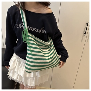 Detail of green and white striped canvas tote bag with lace bow and wide shoulder strap