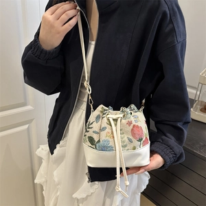 Fashionable floral embroidery bucket bag with white leather base and drawstring strap