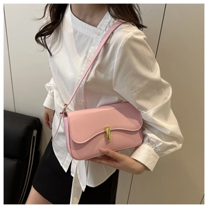 Detail view of pink rectangular baguette bag with gold-tone oval swivel lock and leather strap