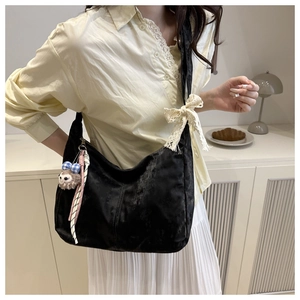 Détail du sac cabas en velours noir avec nœud en dentelle et breloque mouton doux