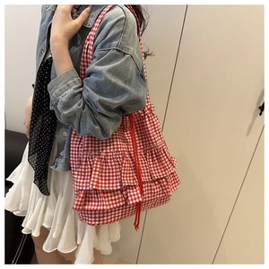 Close-up of red and white checkered tote bag featuring decorative tiered ruffle accents