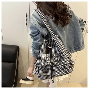 Detail of Korean style black and white checkered tote bag with tiered ruffles and drawstring