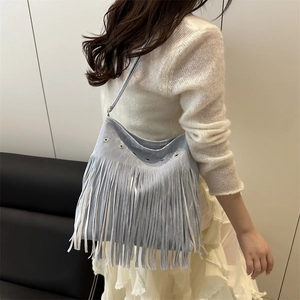 Light blue faux suede tassel tote bag with metal eyelets in a minimalist bohemian style
