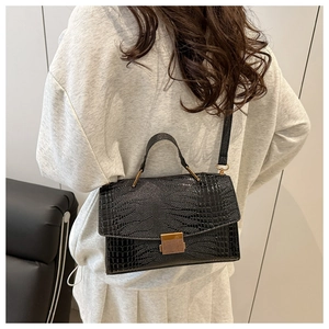Vue portée du sac à main noir effet croco avec boucle dorée et bandoulière en cuir