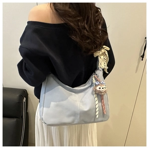 Détail du grand sac cabas bleu clair avec surpiqûres, nœud dentelle et peluche