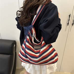 Striped canvas tote bag with blue lace bow accent and wide shoulder strap