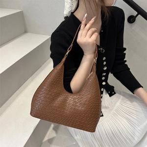 Brown vintage crescent hobo bag with woven texture and minimalist shoulder strap style