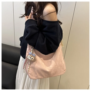 Détail d'un grand sac à bandoulière rose avec un pendentif en peluche mignon