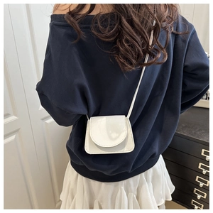 Rear view of model wearing a white mini crossbody square bag with lychee leather texture
