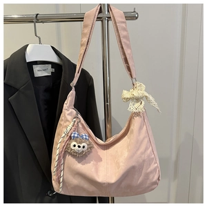 Détail du sac demi-lune rose avec nœud en dentelle et pendentif en peluche doux