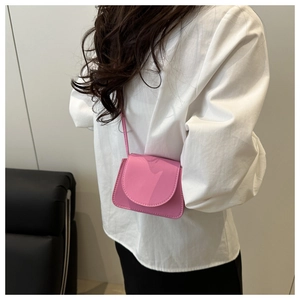 Close-up of pink crossbody bag with matte leather finish and magnetic flap closure