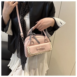 Close-up of pink PU shell bag featuring lace trim and decorative ribbon on handle
