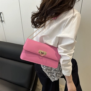 Sac baguette rose avec bandoulière chaîne dorée et fermoir D porté par un mannequin