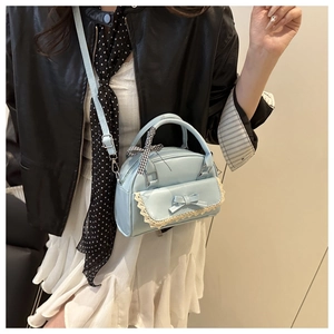 Detail of light blue bow and lace trim on a stylish lady shell shoulder bag